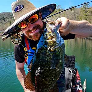 happy fly fisherman with large smallmouth bass