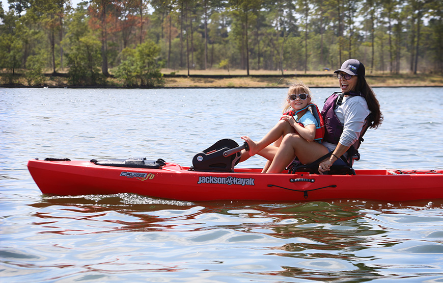 happy sisters smiling in Jackson Kayak Cruise FD on the water.