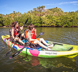 happy mother and son paddling on a sunny day in a taketwo kayak