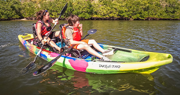 happy mother and son on sunny day paddling a taketwo kayak