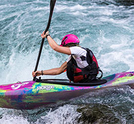 Person kayaking in whitewater.